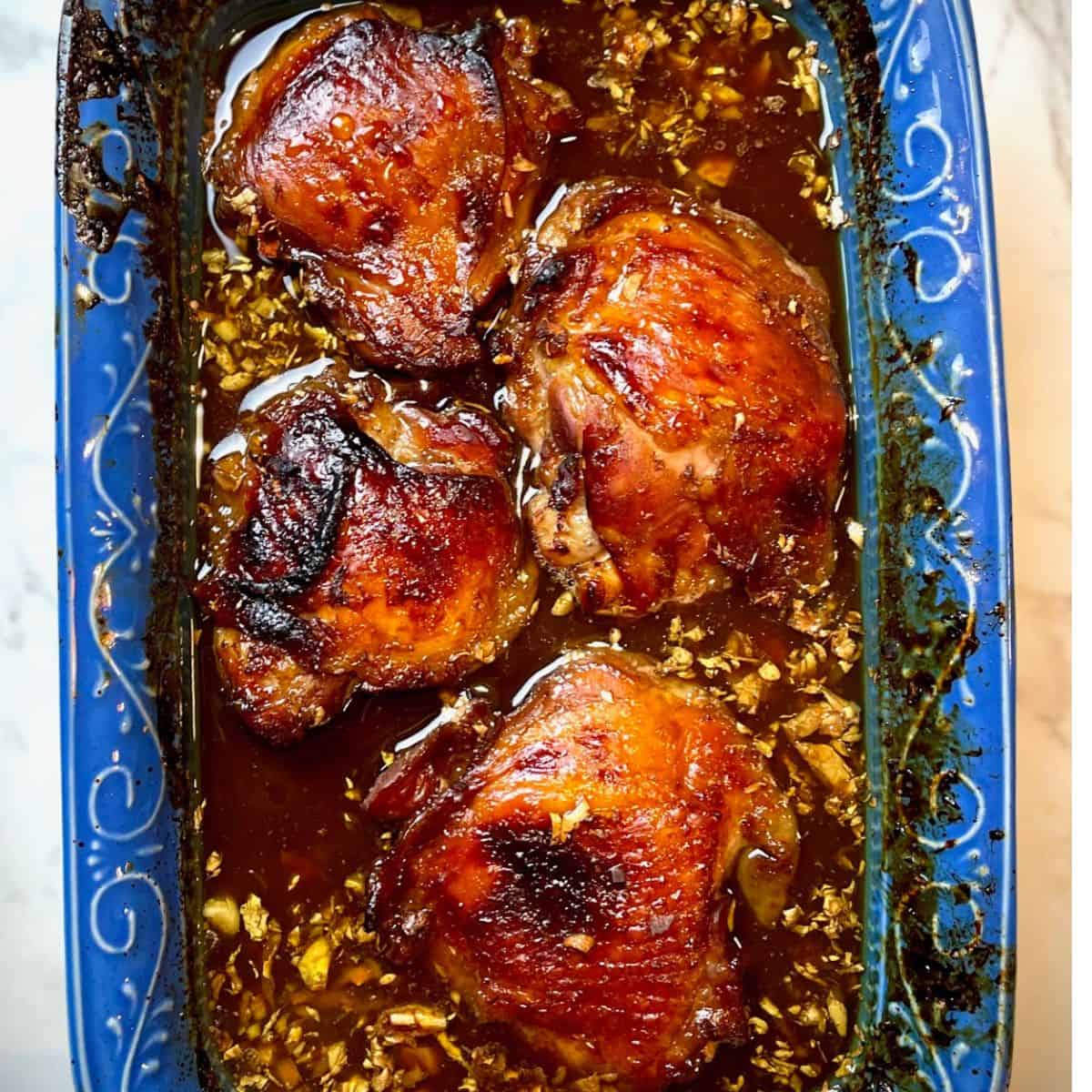 Sticky pomegranate chicken in a blue dish.