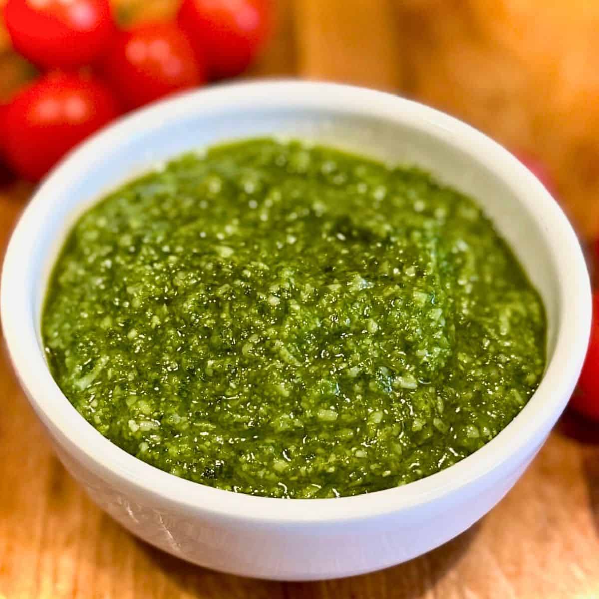 Basil pesto in a white bowl.