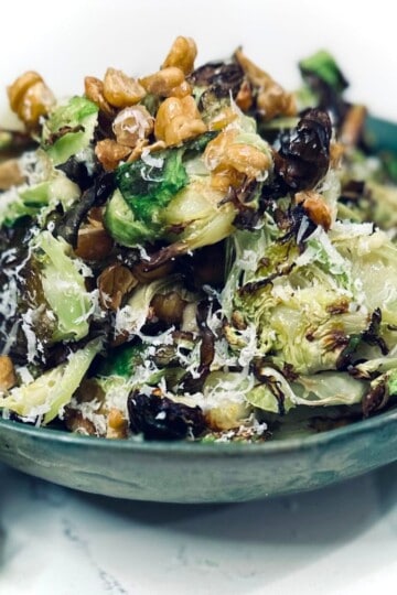 Roasted brussel sprout salad in a green bowl.