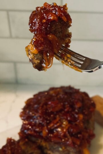 Meatloaf with tomato onion jam on a fork.