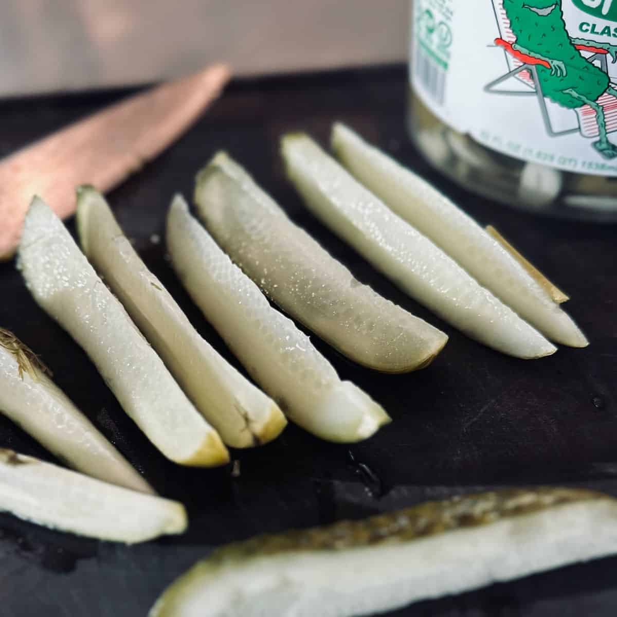 Sliced pickles on a cutting board.