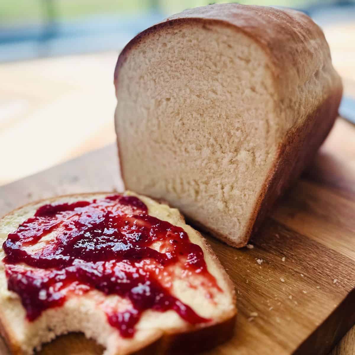 Cottage cheese bread loaf, with one slice with butter and jam.