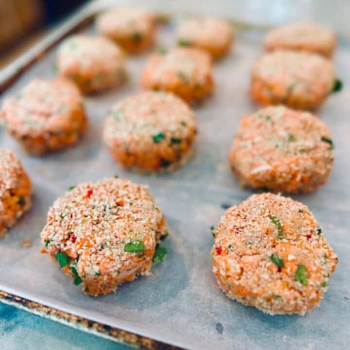 Raw salmon cakes on a sheet pan.