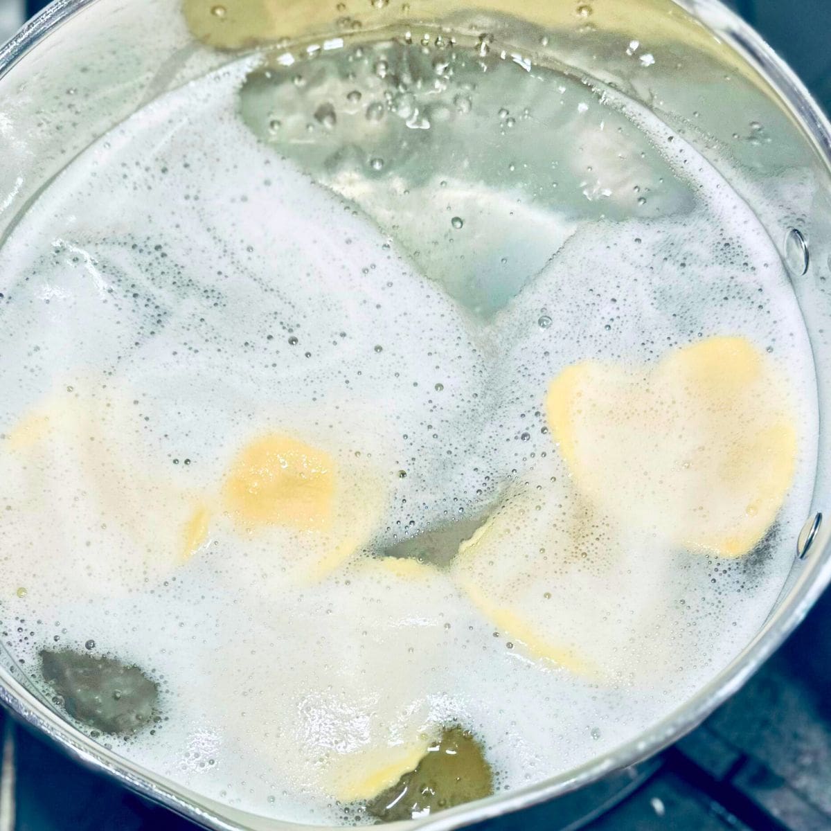 Ravioli in a pot of boiling water.