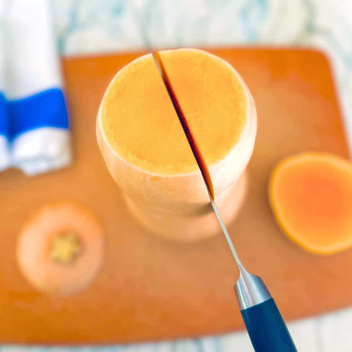 Cutting butternut squash in half.