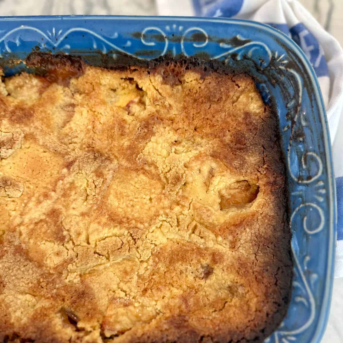 Peach dump cake in a blue baking dish.