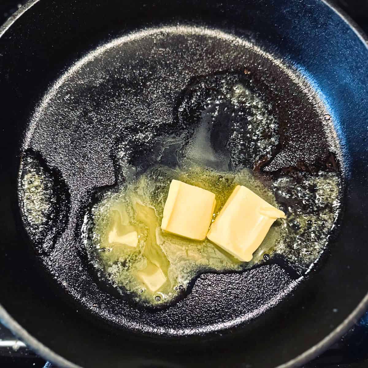 Butter melting in a cast iron skillet.