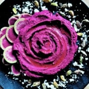 Roasted beet hummus on a black platter.