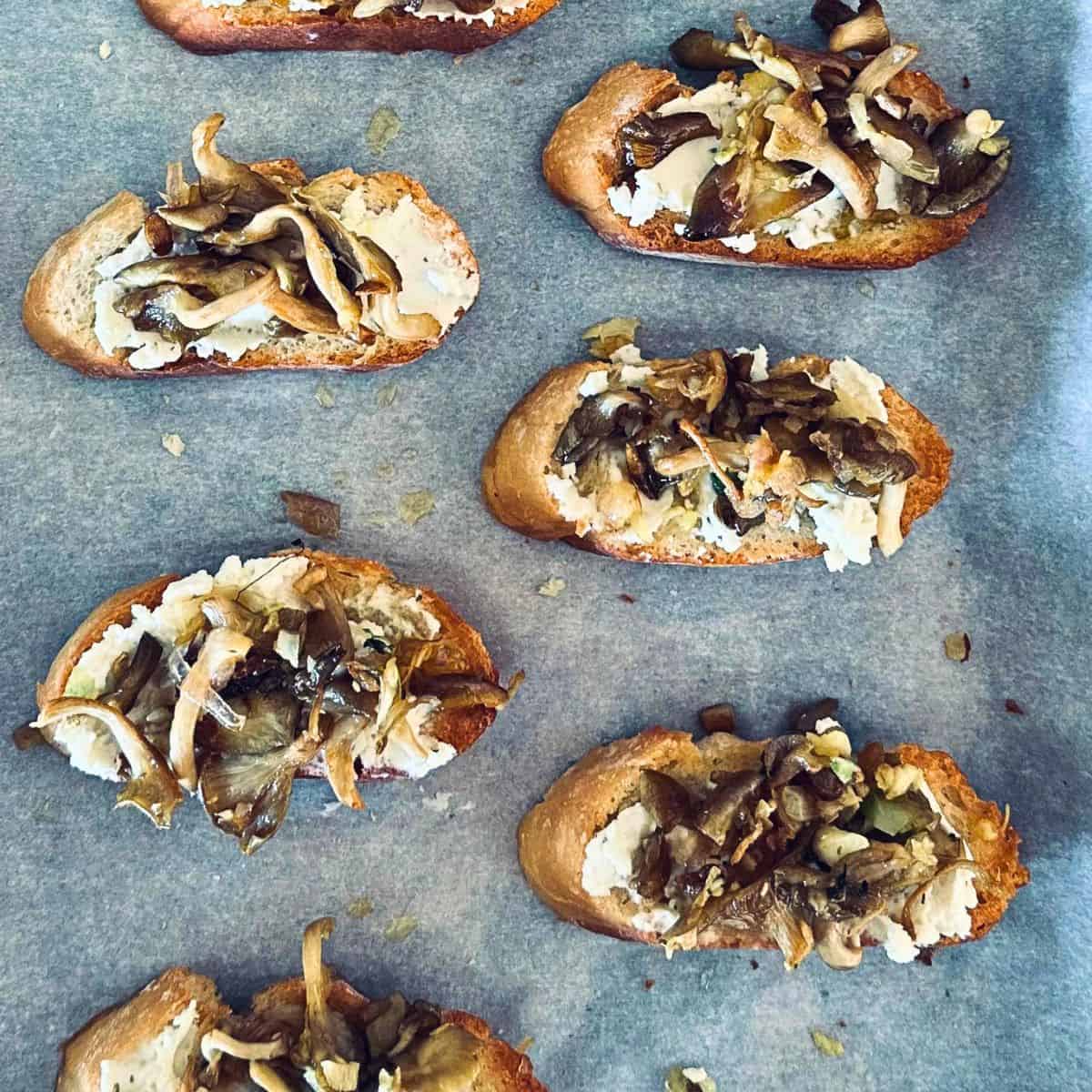 Birdseye view of wild mushroom crostini on a baking sheet.